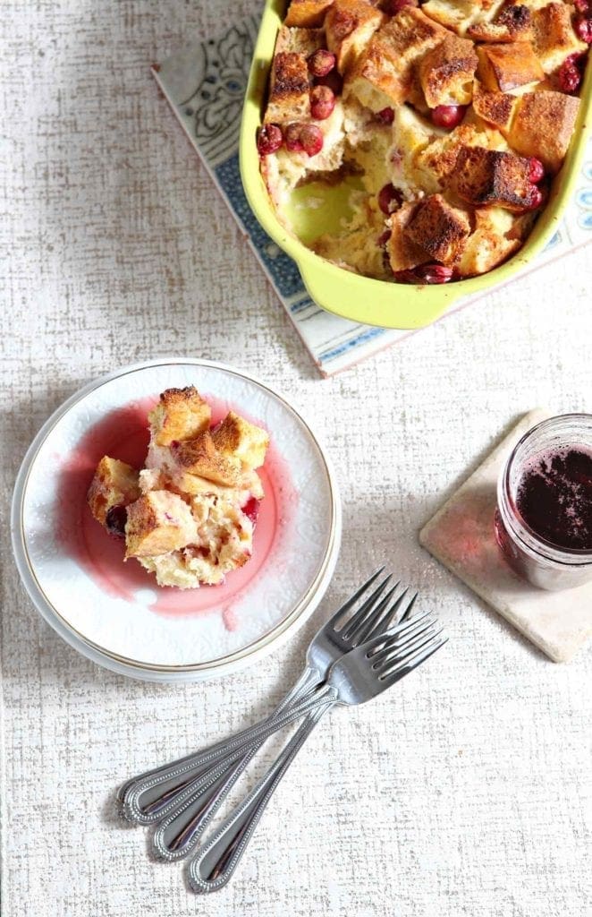 Overhead view of french toast casserole on plate with casserole dish and drink 