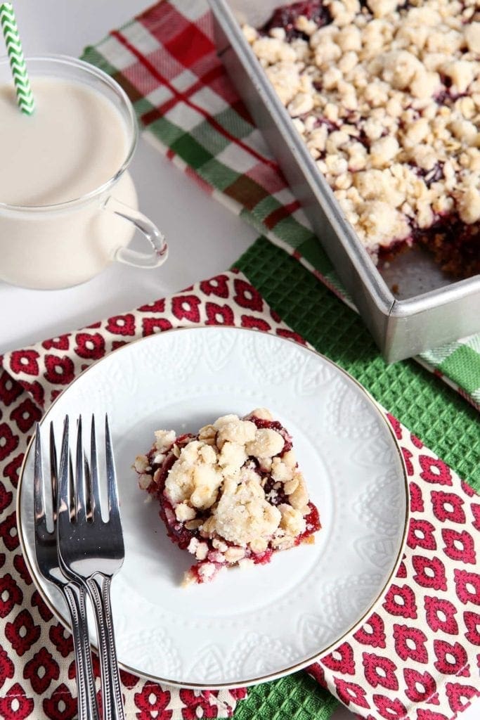 Cranberry crumb bar on plate with milk and baking pan 