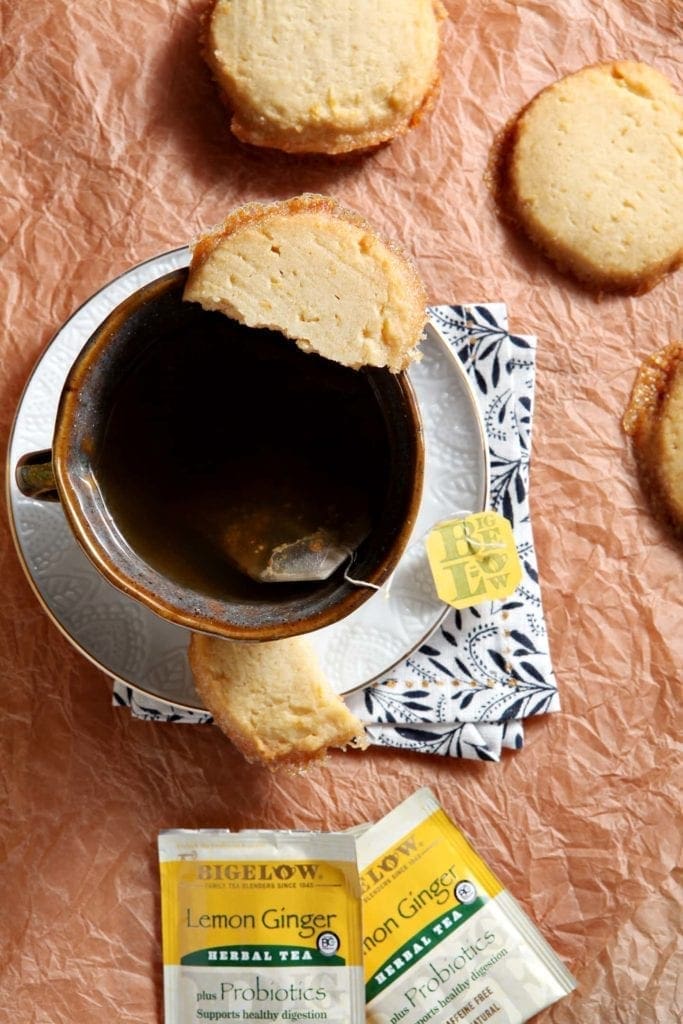 Overhead view of a cup of tea with lemon honey shortbread on rim 