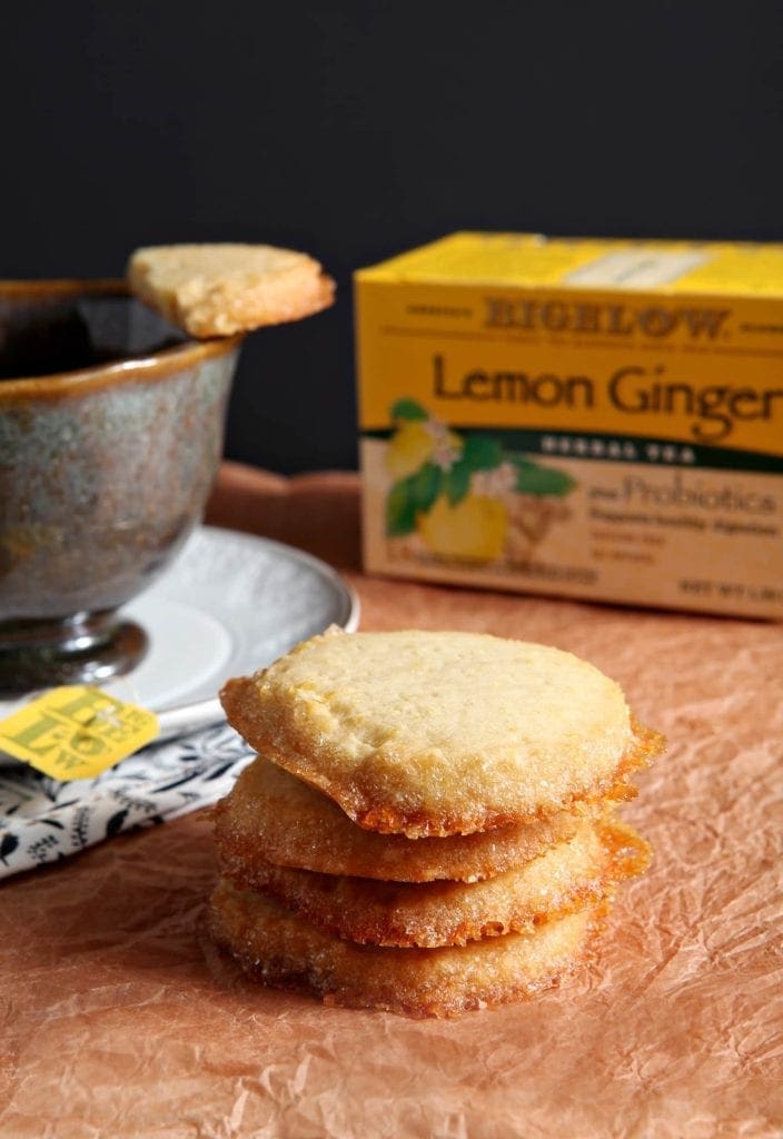 Stack of shortbread cookies in front of cup of tea and tea package