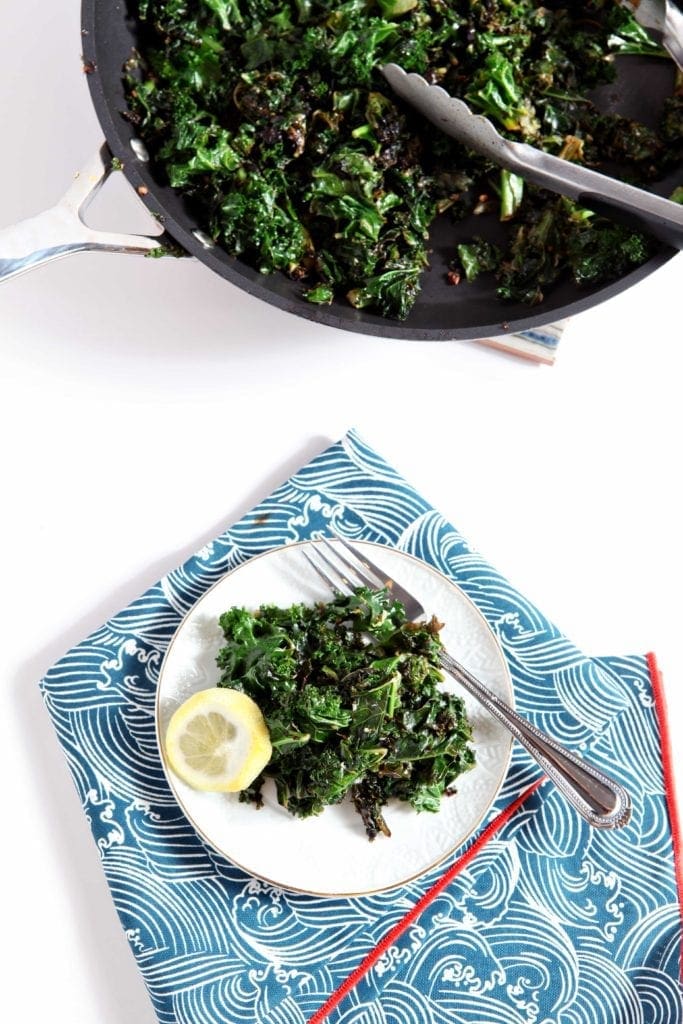 Lemon Kale on small plate with fork and lemon slice garnish