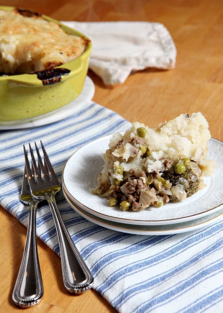Piece of Shepard's Pie on white plate with forks 