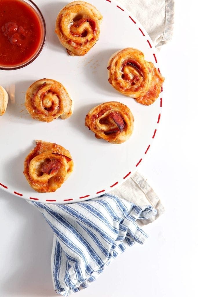 Overhead of a platter of Pepperoni Pizza Rolls, served with marinara sauce