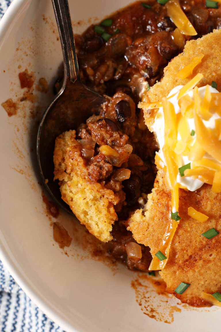 Close up of a bowl of Cornbread Chili Casserole with a spoon inside it