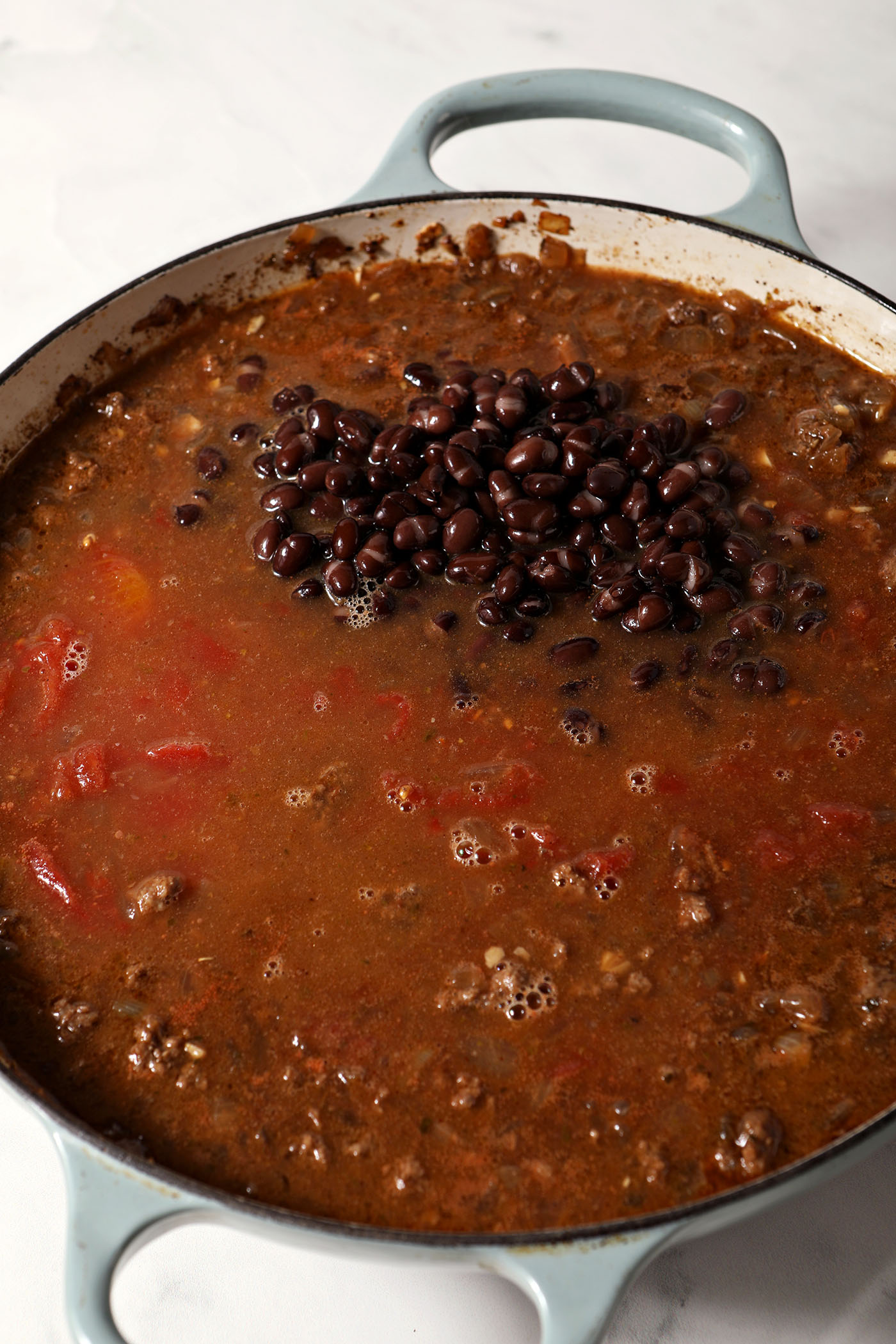 All chili ingredients in a braised pan before mixing