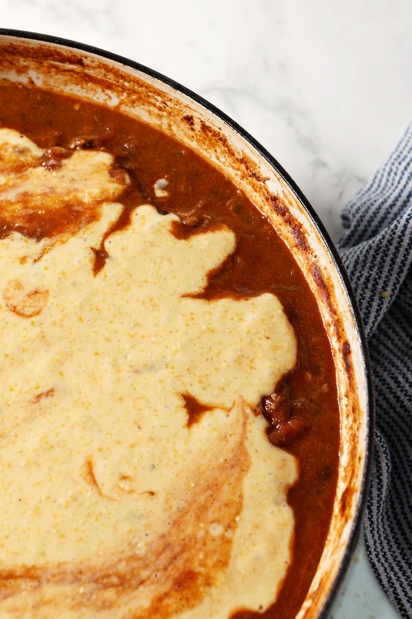 Cornbread batter on top of chili before baking