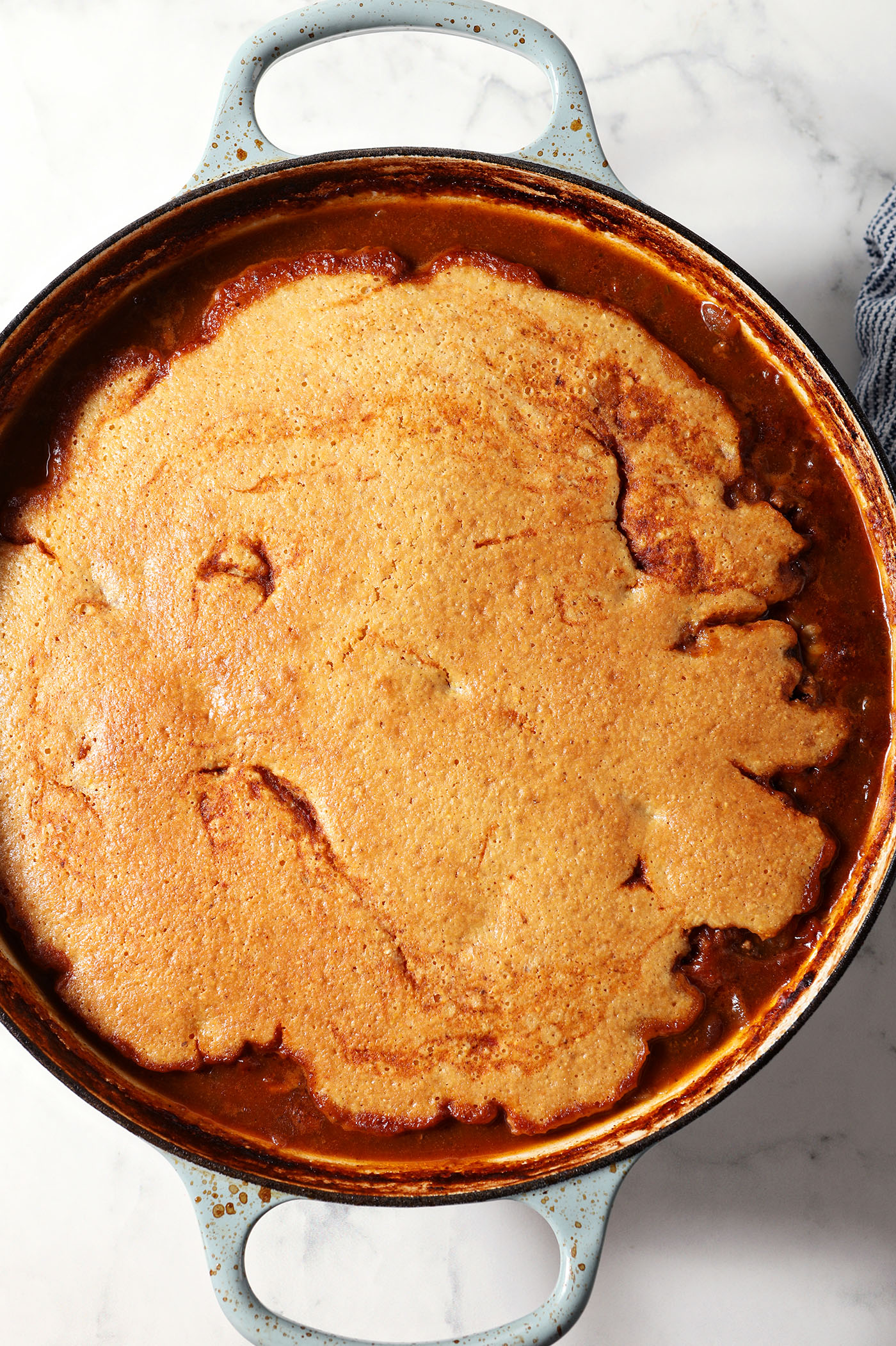 A braiser pan full of Chili Cornbread Casserole after baking