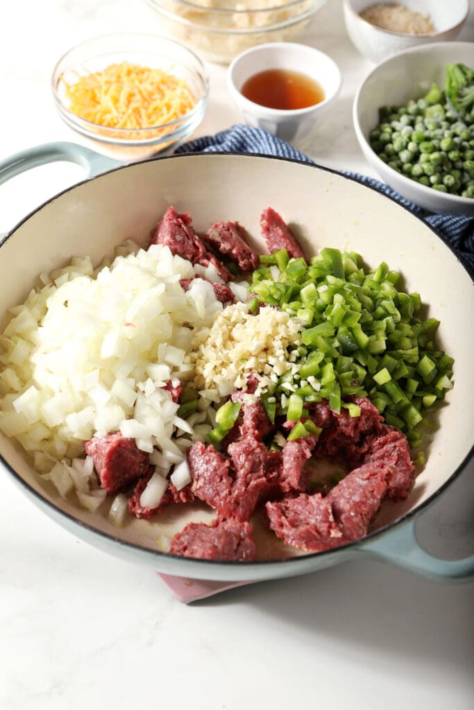 Ground beef and veggies in a round dish as they cook