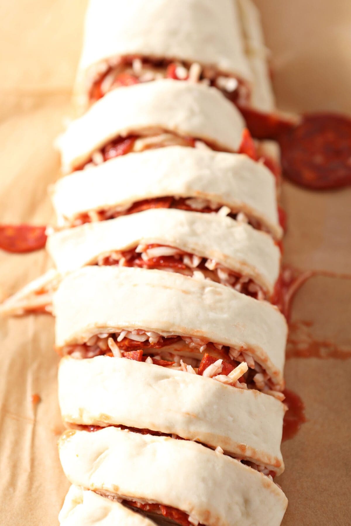 Close up of the sliced pizza rolls on parchment before moving them to the baking sheet