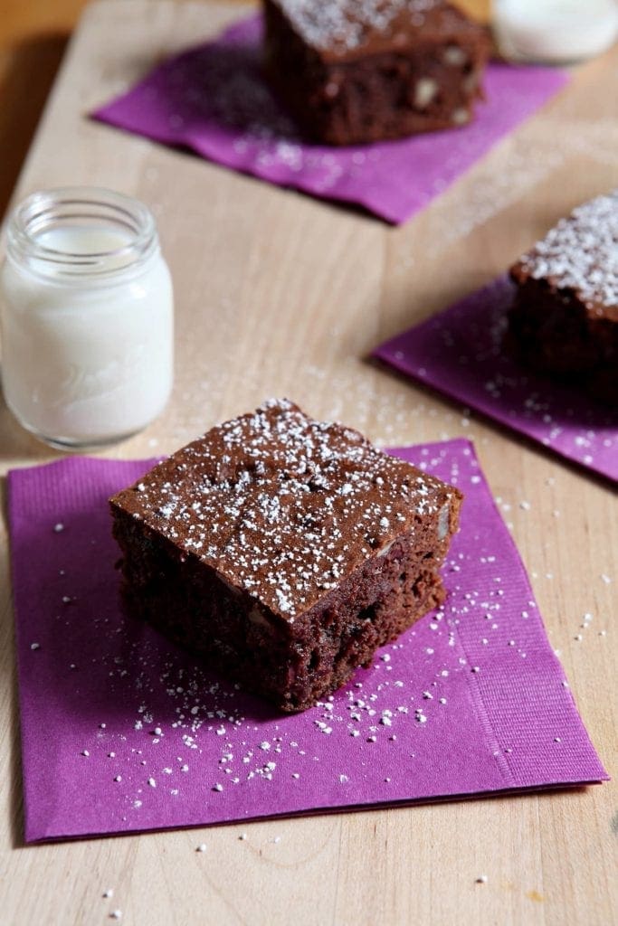 close up of bourbon pecan brownie on a purple napkin