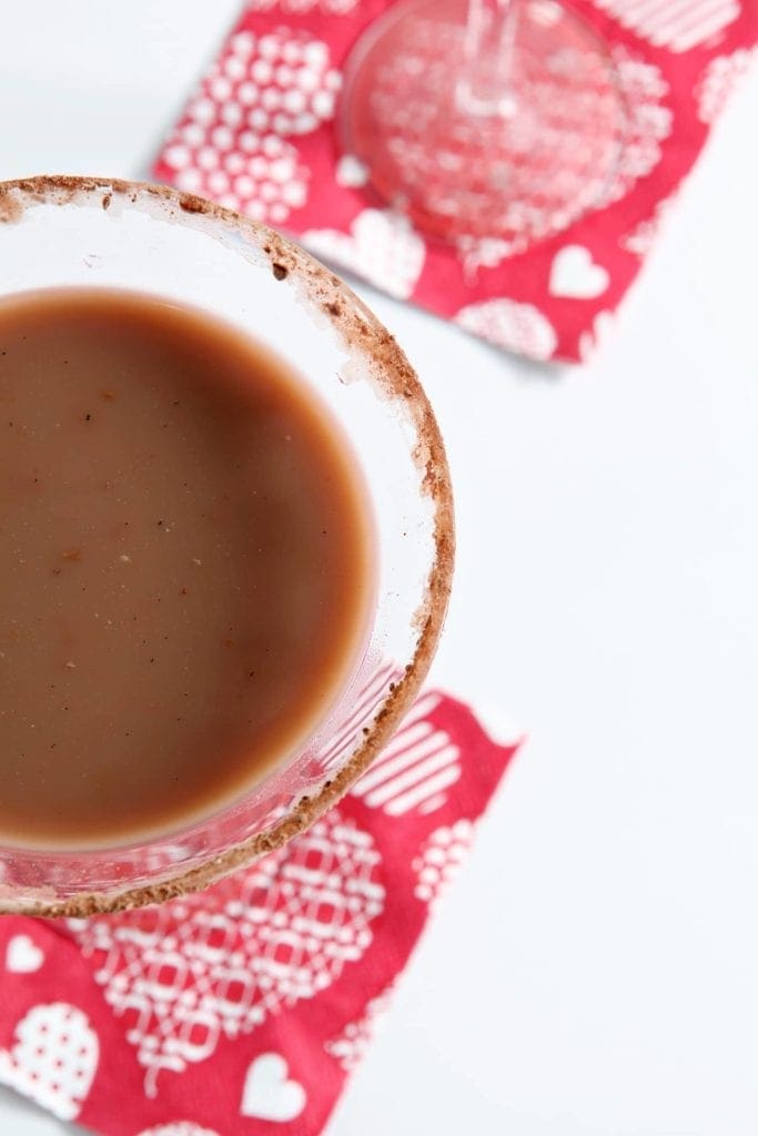 Close up of vanilla hot chocolate martini in glass with seasoned rim 