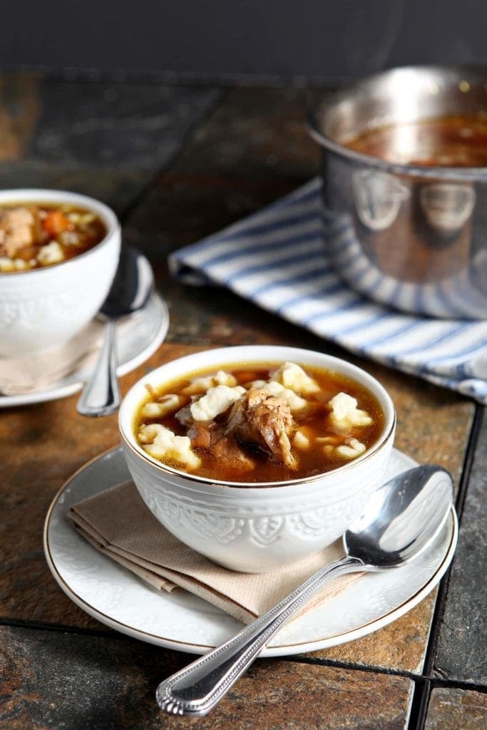 chicken spaetzle soup in white bowls with spoons