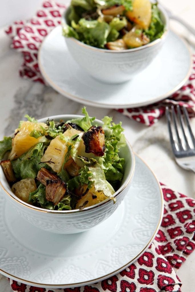 Two white bowls of Roasted Fennel Orange Salad on red and white linens 