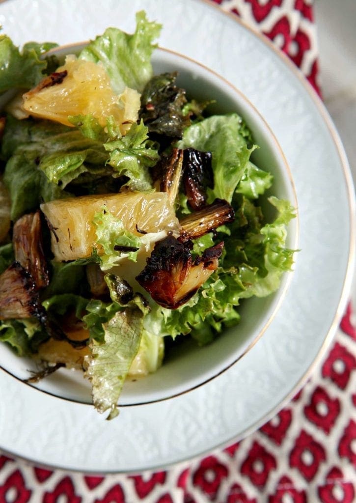 Overhead close up of roasted fennel orange salad in white bowl 