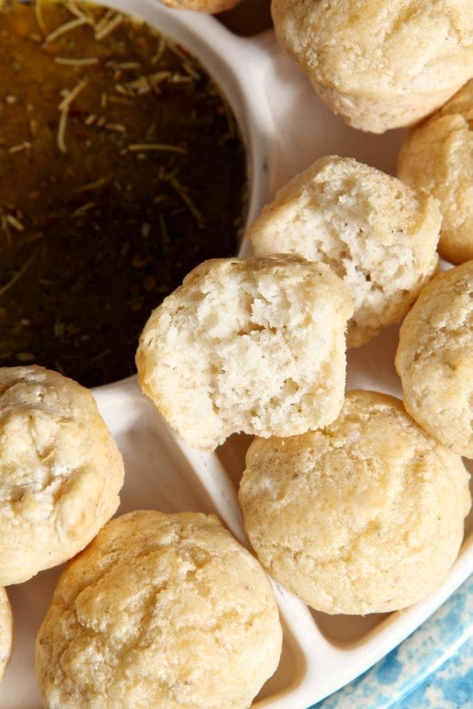 Close up of cut open bread next to dipping sauce 