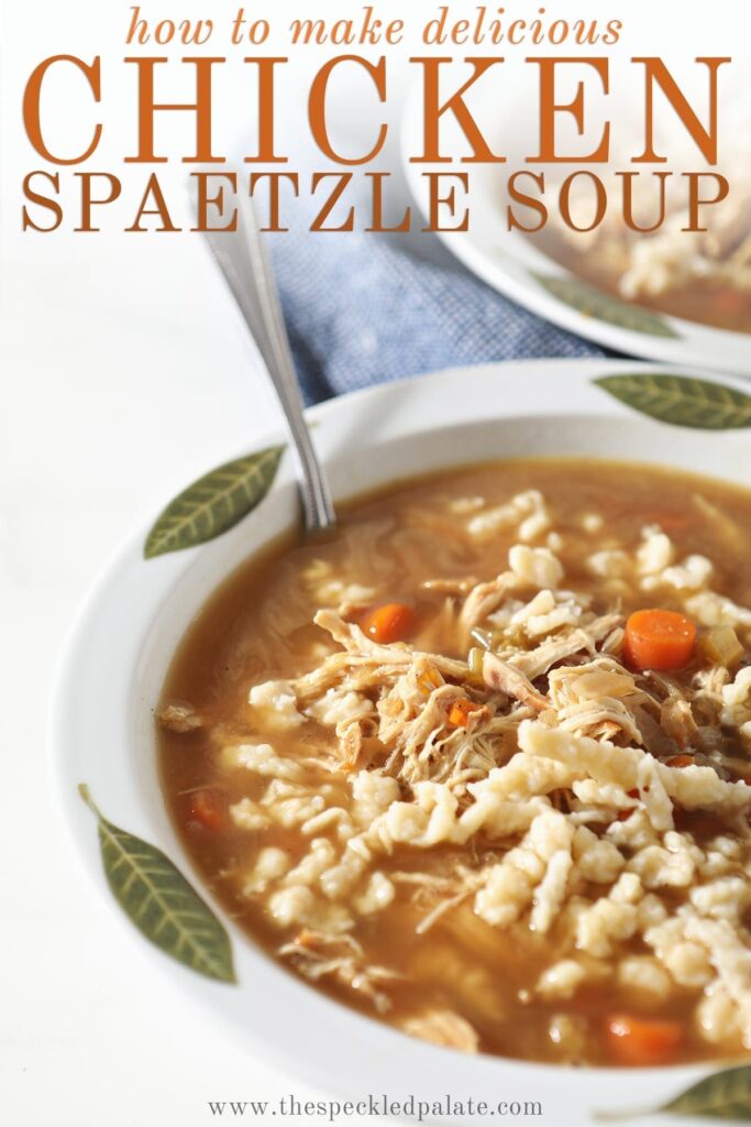 Close up of a bowl of chicken soup with German noodles on marble with a spoon in it with the text 'how to make delicious chicken spaetzle soup'