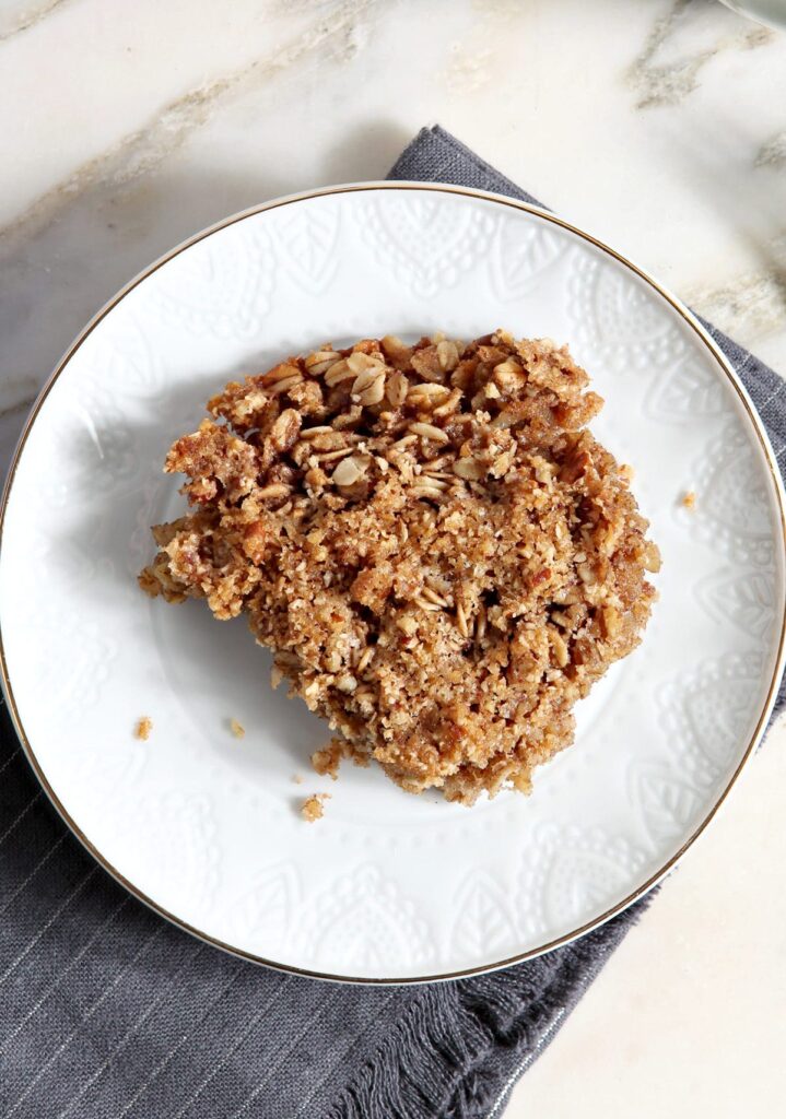 A serving of baked oats on a white plate on marble