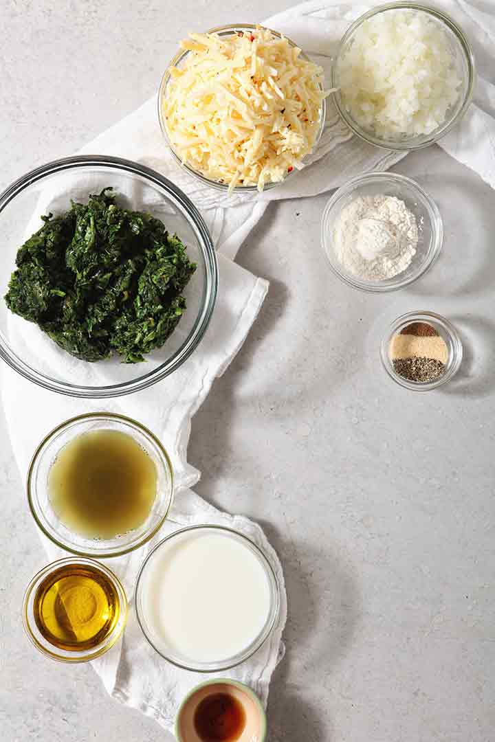 Ingredients for spicy creamed spinach are shown on a background