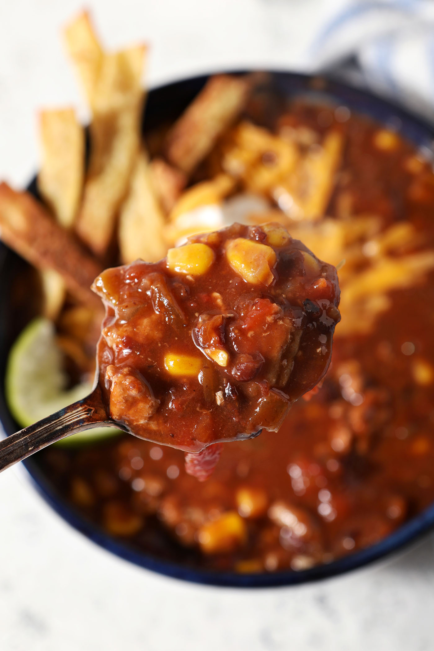 A spoonful of taco soup above a garnished bowl