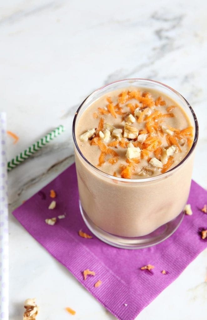 Vegan carrot cake smoothie in glass on purple napkin
