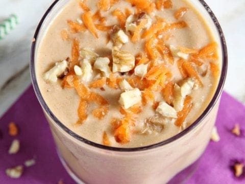 Angled overhead view of vegan carrot cake smoothie on purple napkin