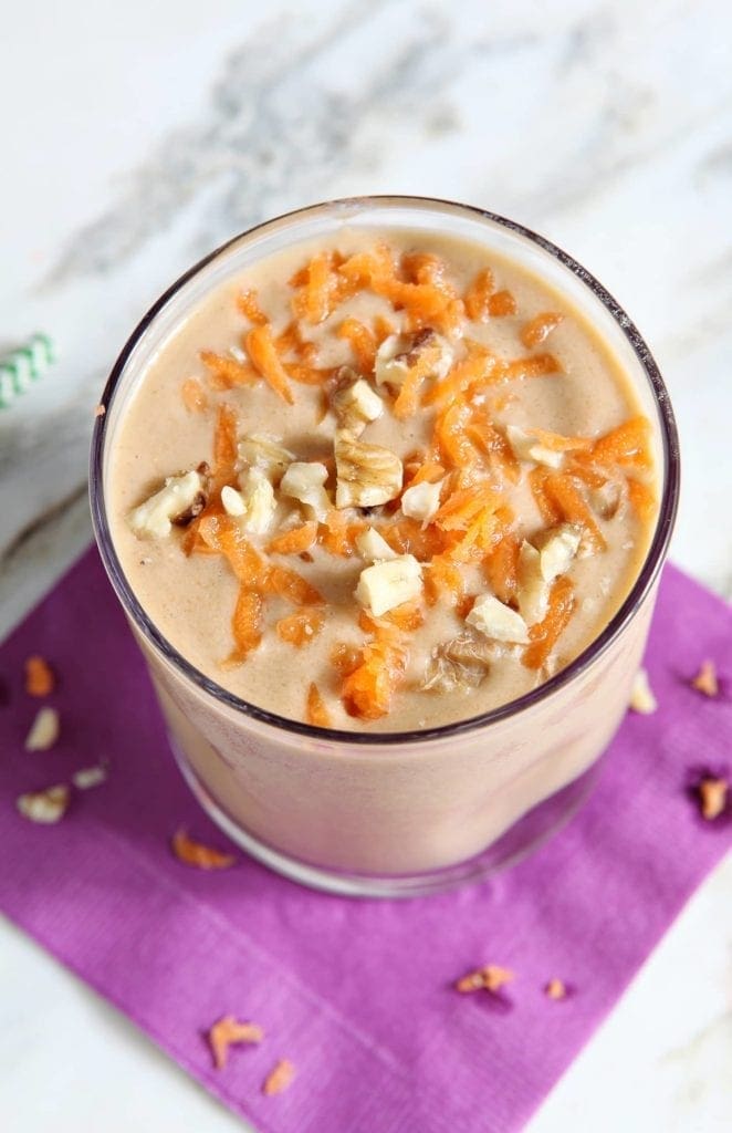 Angled overhead view of vegan carrot cake smoothie on purple napkin 