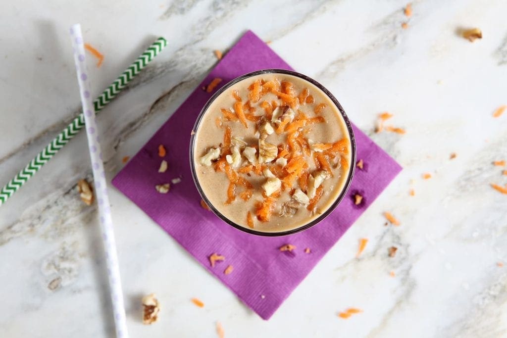 Overhead view of vegan carrot cake smoothie on purple napkin 