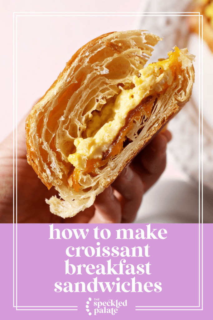 a halved croissant breakfast sandwich held in hand above a pink surface with the text how to make croissant breakfast sandwiches