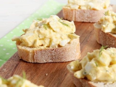 Angled view of Deviled Egg Bruschetta sitting on wood board