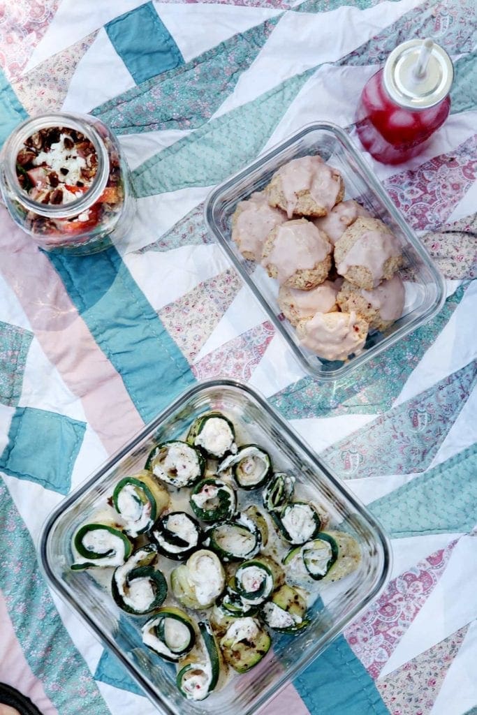 Overhead view of foods in containers on picnic blanket 