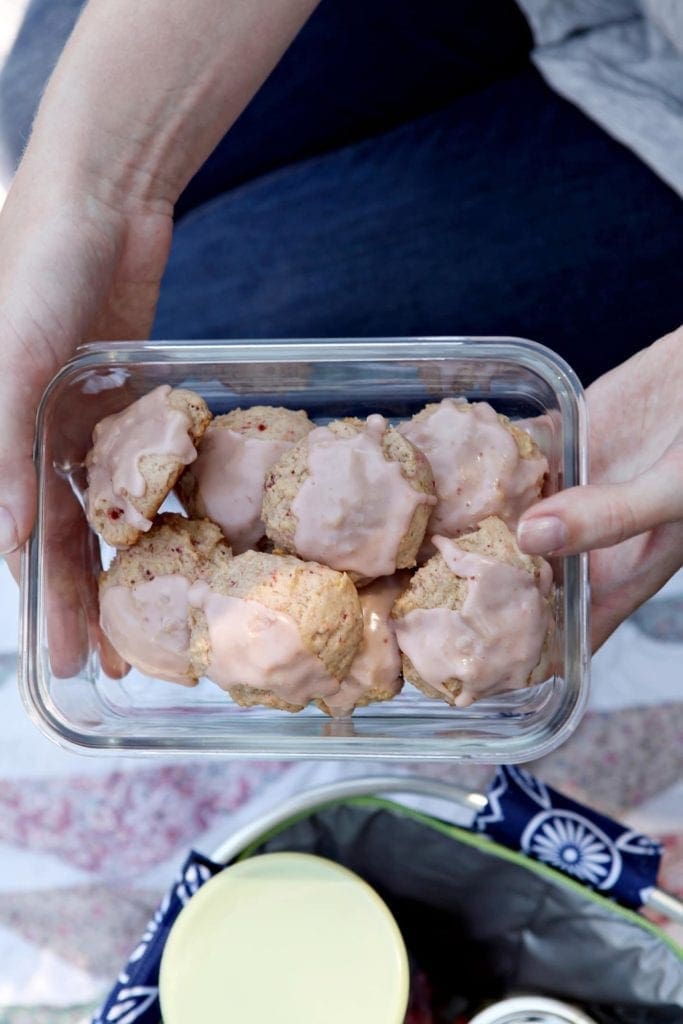 Overhead view of person holding a glass dish of vegan strawberry lemonade cookies 