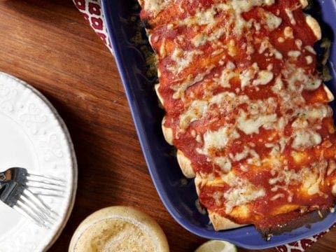 Overhead of enchiladas, with melty cheese in blue dish