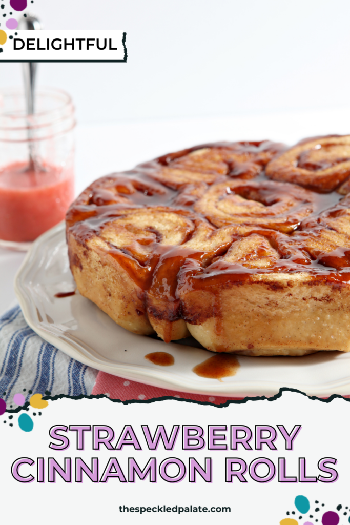 Baked strawberry cinnamon bun on white serving dish with drizzled glaze