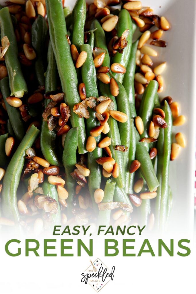 Close up of a platter holding Vegan Green Beans garnished with Toasted Pine Nuts and shallots with the text 'easy, fancy green beans'