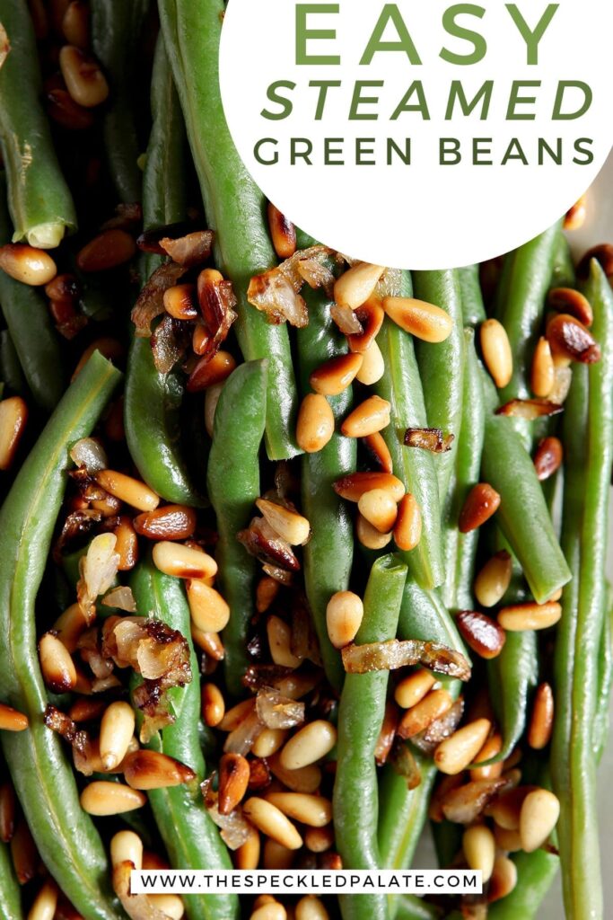 Close up of a platter holding Vegan Green Beans garnished with Toasted Pine Nuts and shallots with the text 'easy steamed green beans'