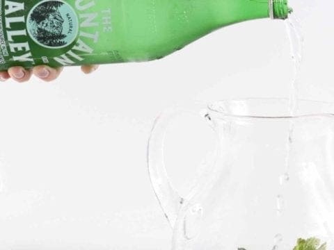 Water pouring in a pitcher of blackberries and mint