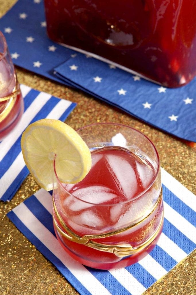 cherry lemon tea in a glass with a lemon wedge