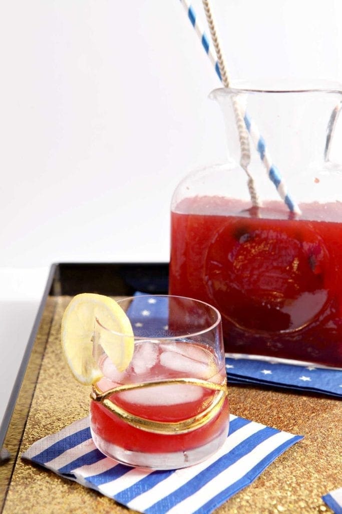 Cherry lemon tea in glass and in pitcher on decorative napkin 