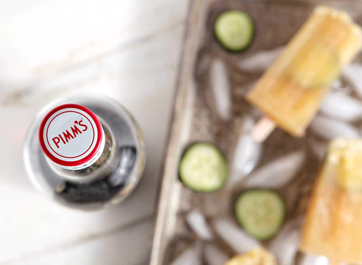 Overhead view of top of bottle cap next to tray of popsicles 