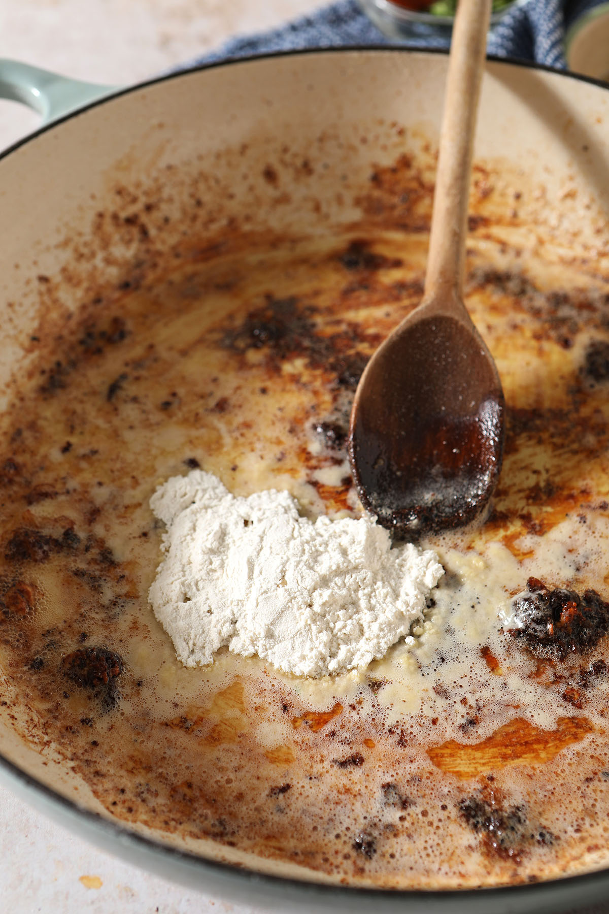 Flour on top of butter in a skillet after chicken was seared in it
