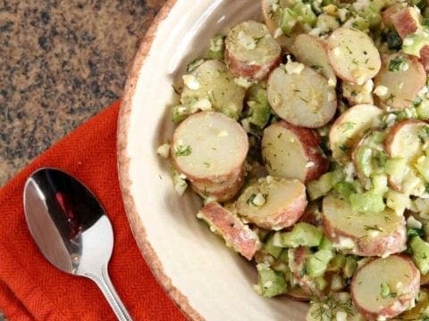 A bowl of No Mayo Potato Salad sits on a granite countertop, ready for serving