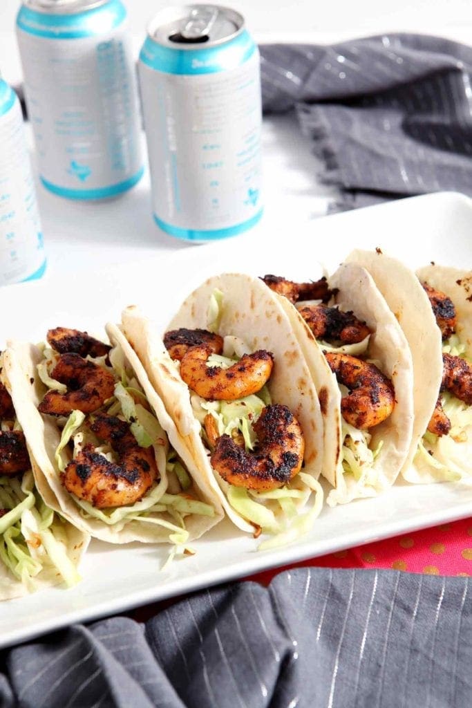 A platter of Blackened Shrimp Tacos is served with beer