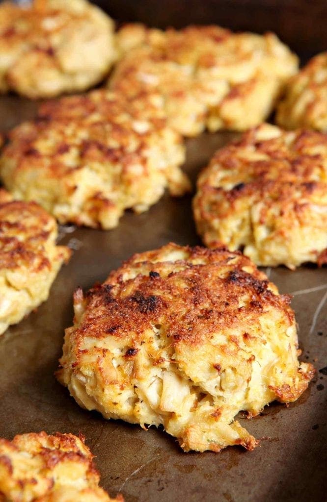 Close up of broiled crab cakes on baking sheet 