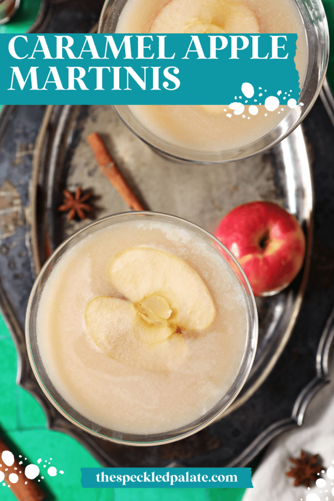 Overhead of two salted caramel appletinis garnished with apple slices on a silver tray with spices and an apple with the text caramel apple martinis