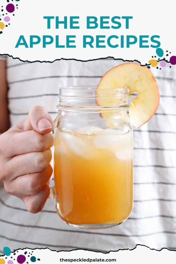 A woman holds an orange drink garnished with a wheel of apple with the text "The Best Apple Recipes"