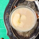 Overhead of two salted caramel martinis on a silver tray on a green surface