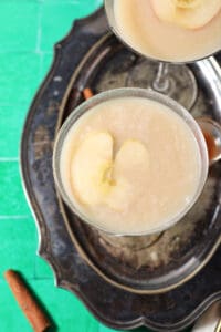 Overhead of two salted caramel martinis on a silver tray on a green surface