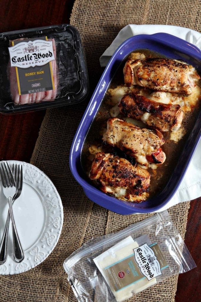 Baked Chicken Cordon Bleu in serving dish with packages of ham and cheese 