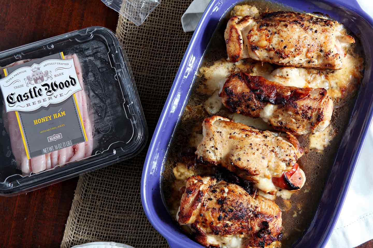 Chicken Cordon Bleu in blue serving dish next to package of ham 