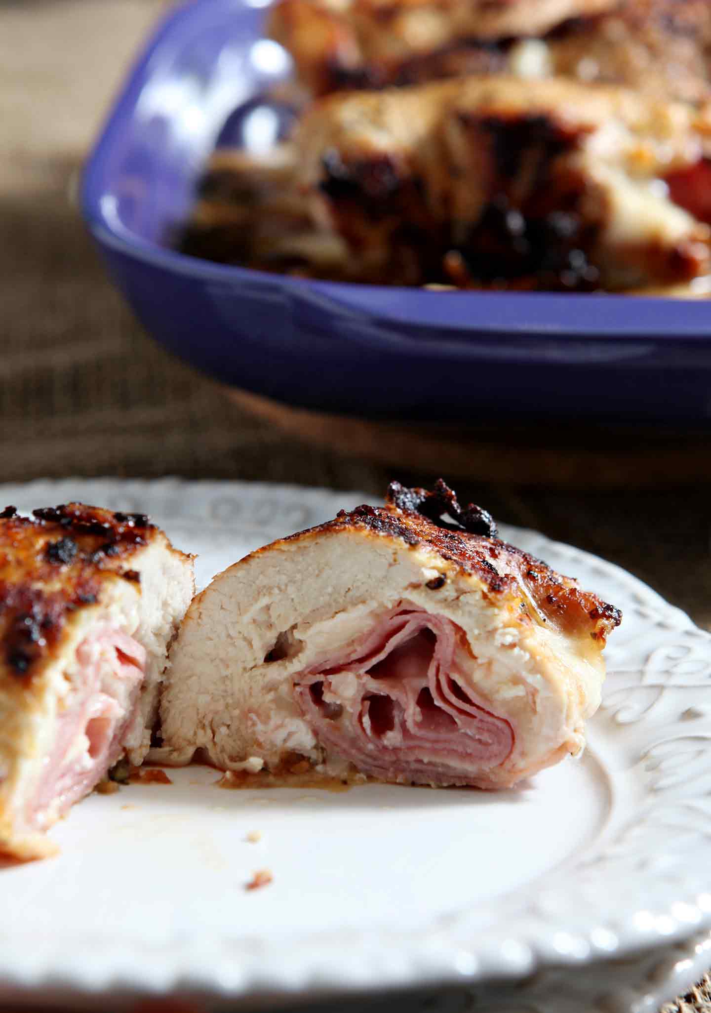 Close up of a Chicken Cordon Bleu cut in half with the baking sheet in the background